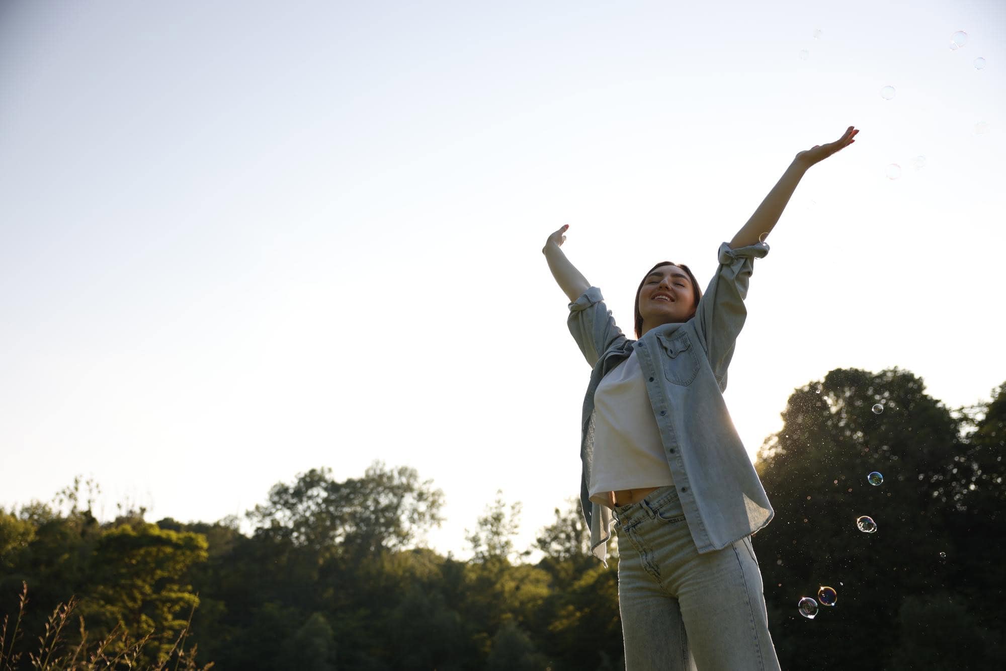 Woman raising her hands while celebrating happiness and positive progress at Axis Behavioral Health.