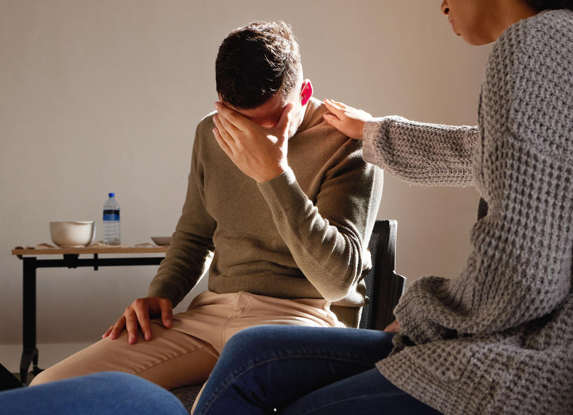 A man is comforted during one on one counseling through depression treatment in Mt. Pleasant, WI.