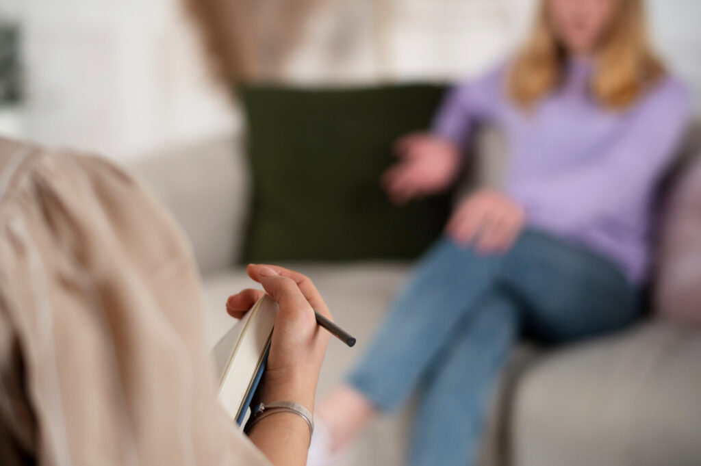 Therapist taking notes while a patient participates in CBT therapy in Mount Pleasant, WI.