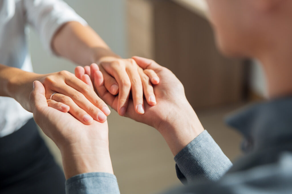 Man holding his wife’s hands while receiving mental health support at Axis Behavioral Health.