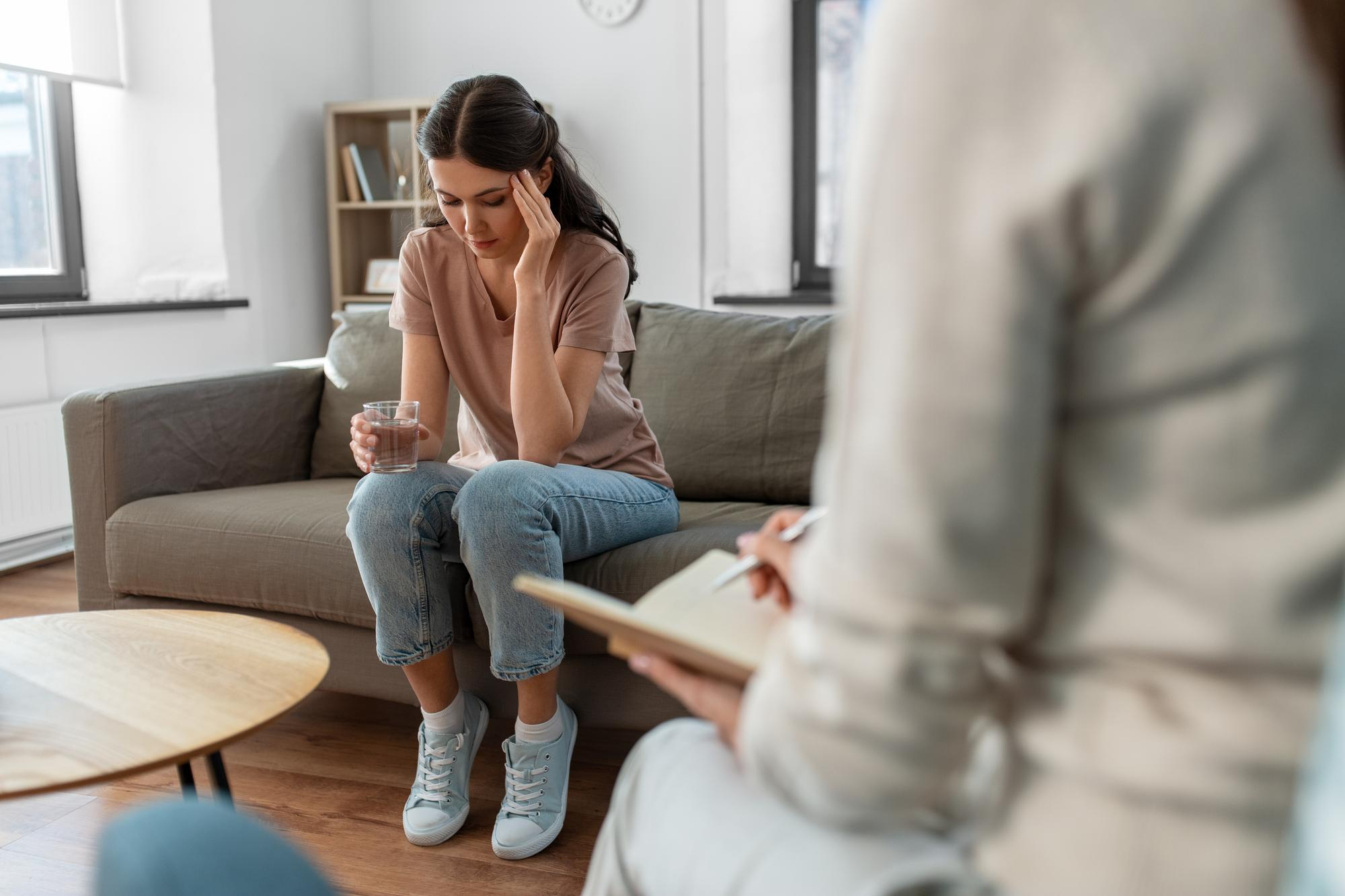 Woman holding a glass of water while listening to her therapist during dialectical behavior therapy in Mount Pleasant, WI.