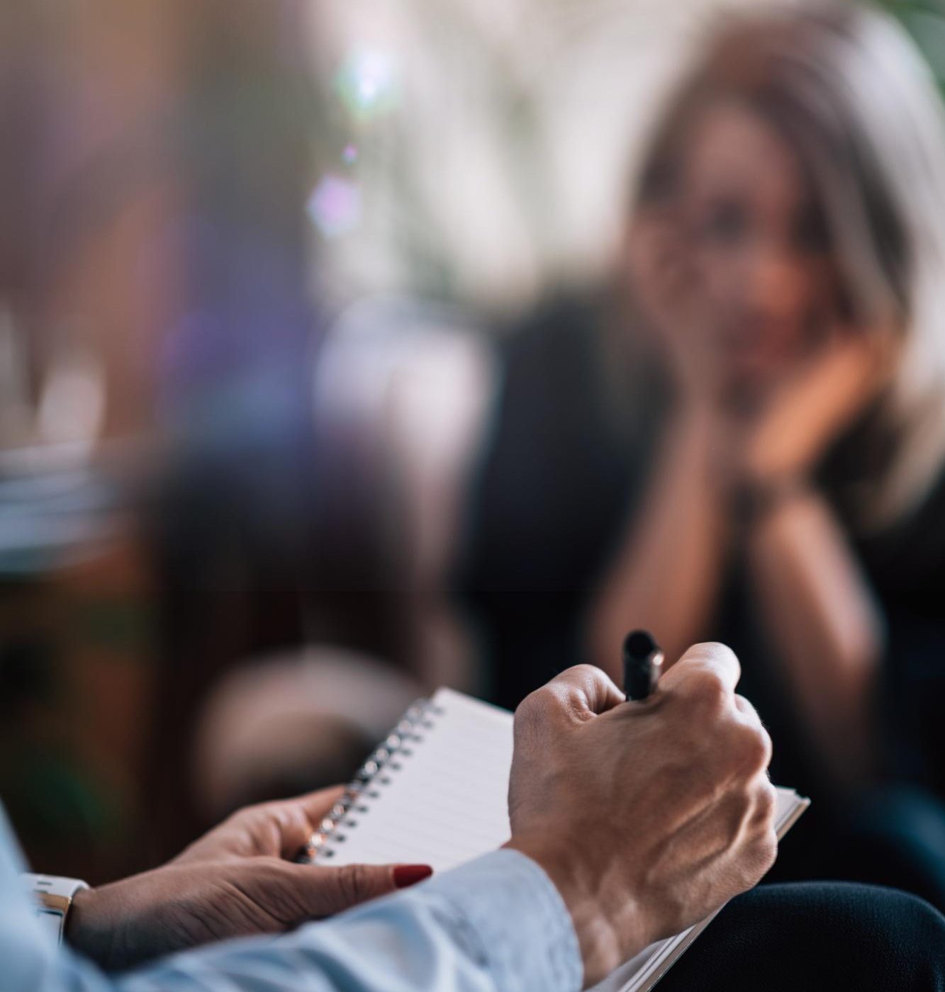 Therapist taking notes while a patient participates in dual diagnosis treatment in Mount Pleasant, WI.