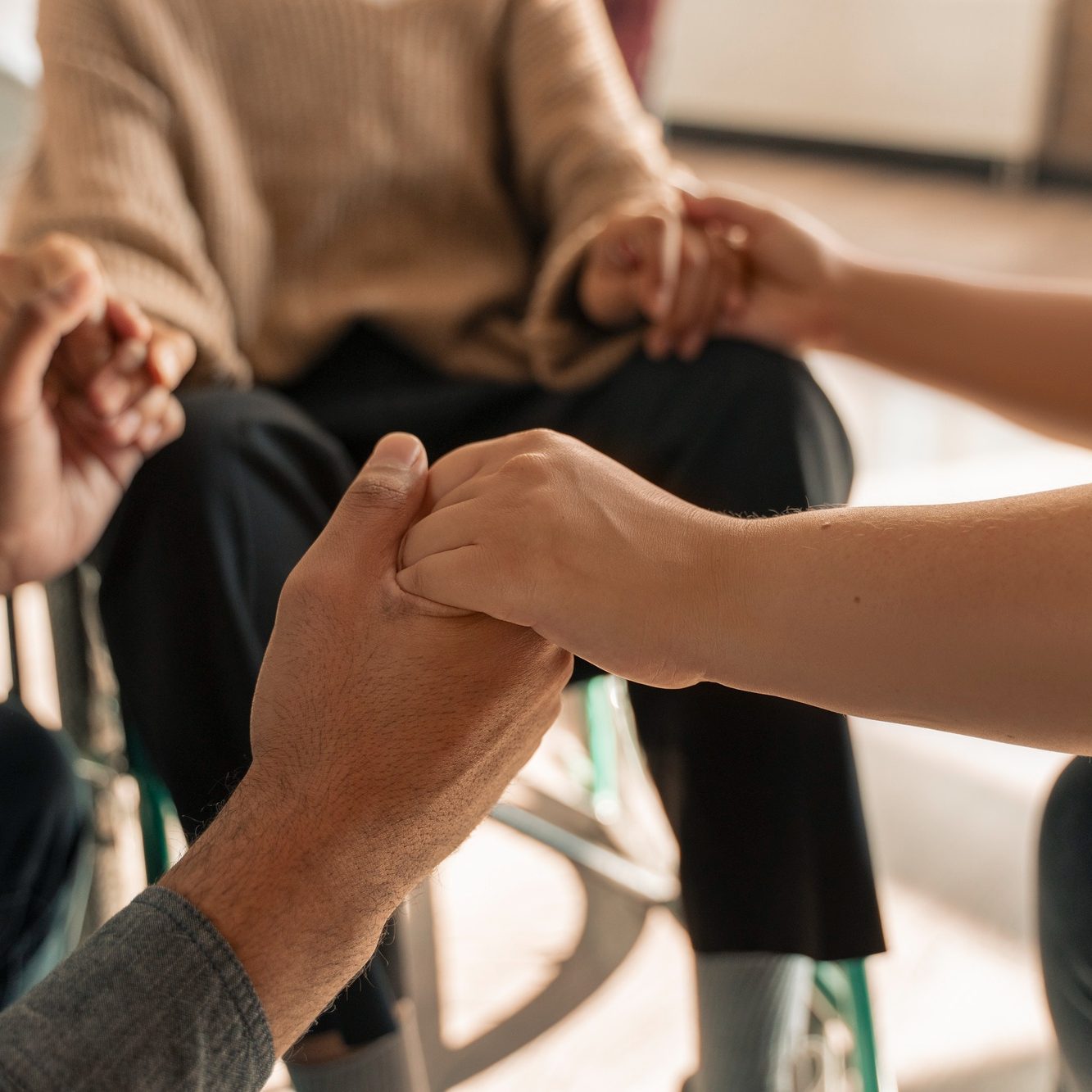 People holding hands during a group therapy session at Axis Behavioral Health
