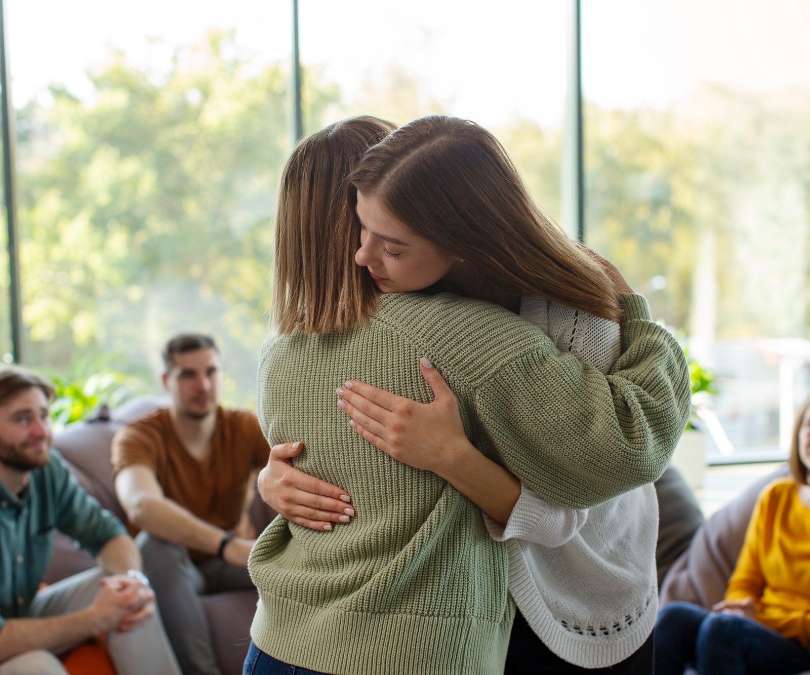 Women embracing during a group therapy session for addiction treatment in Mount Pleasant, WI.
