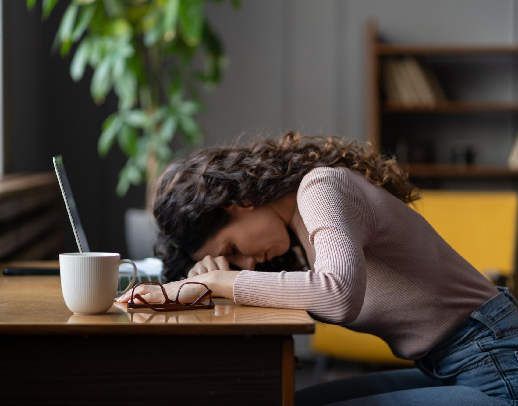 Woman resting her head on a laptop during dual diagnosis treatment in Mount Pleasant, WI.